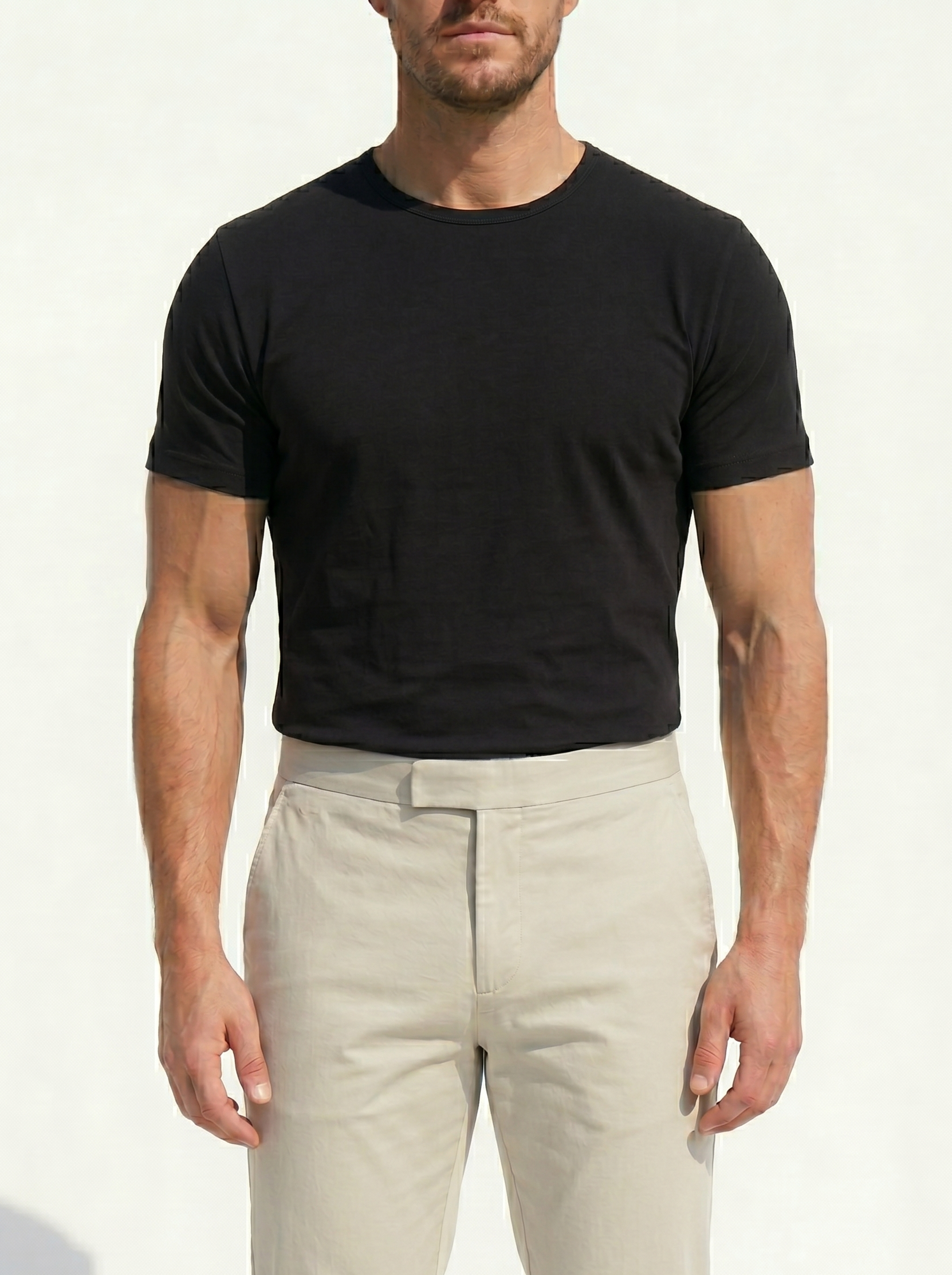 Man wearing a black t-shirt and beige pants on a white background