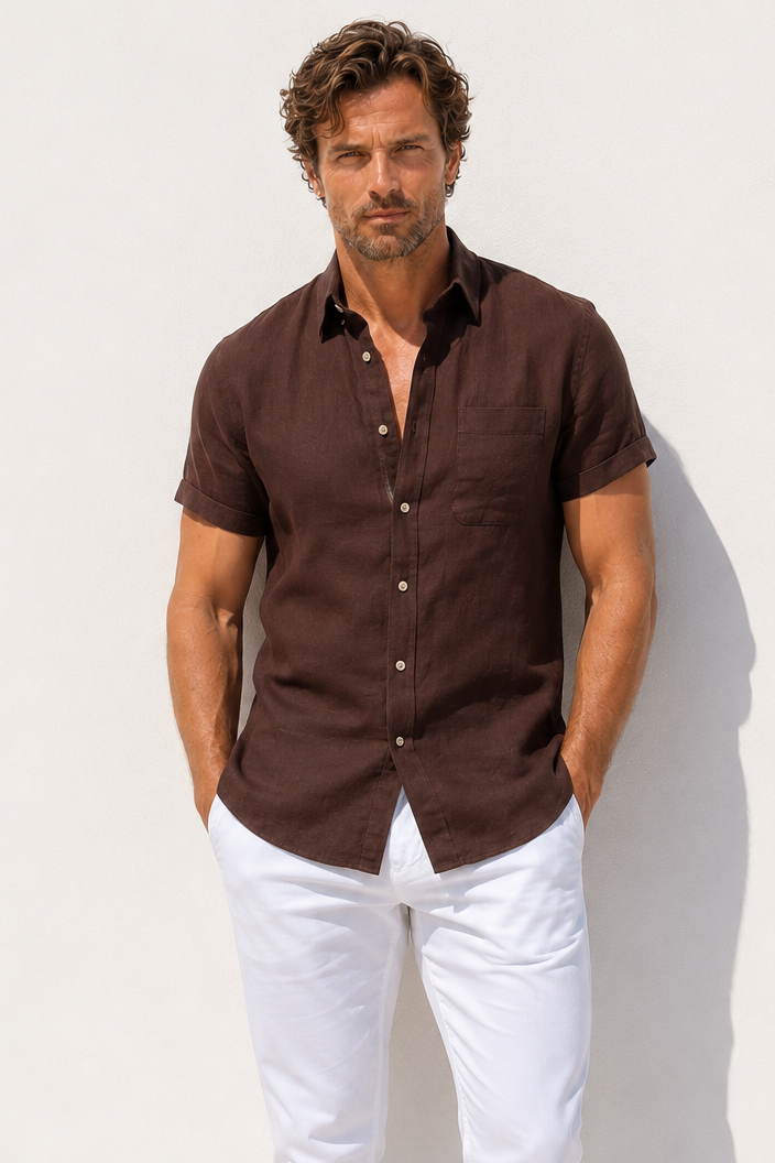 Man wearing a brown shirt and white pants against a white background